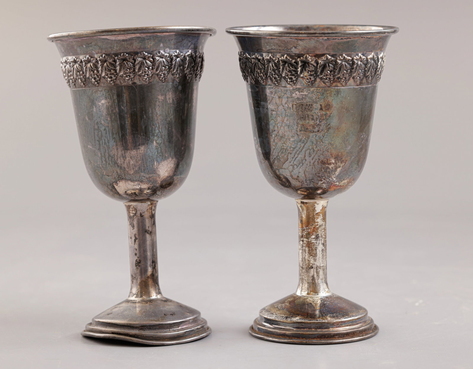 Silver Kiddush Cups: Pair of sterling silver Kiddush cups. Height: 12 cm. Total weight: 111 grams. Hallmarked. Dents to the base of one cup.