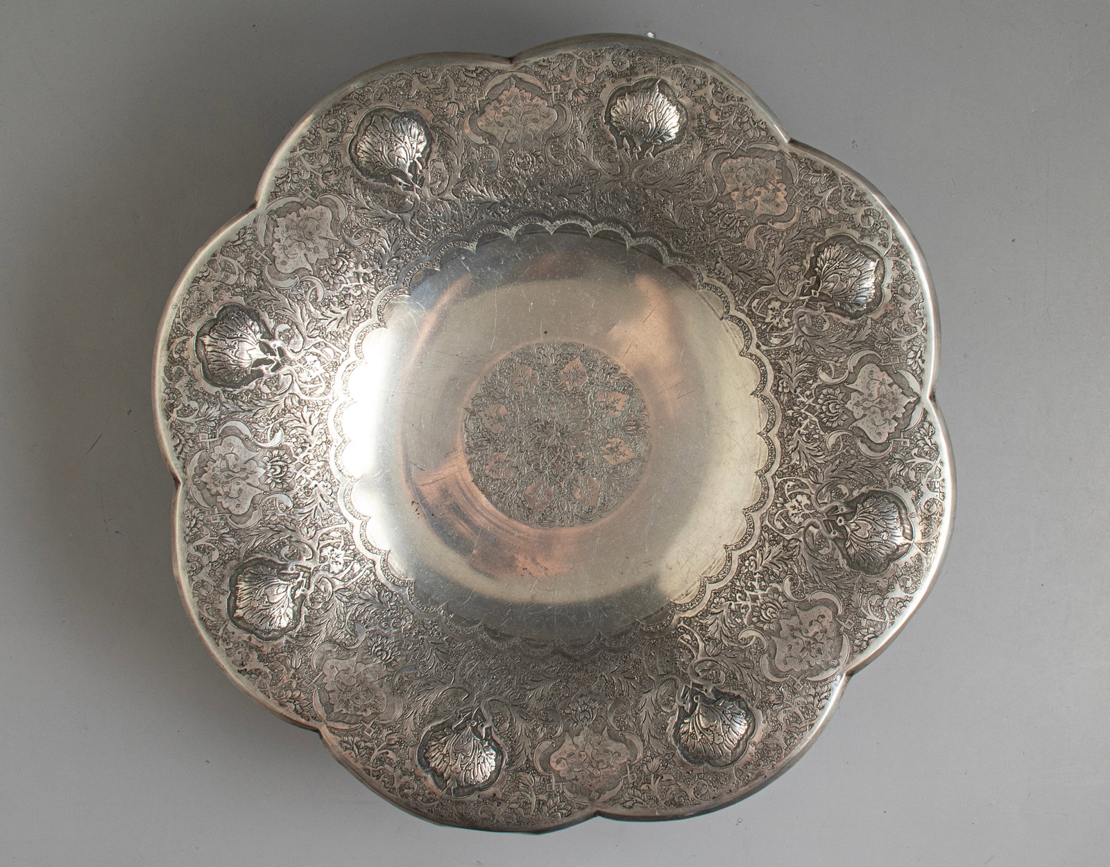 Persian Silver Serving Items: Persian silver footed bowl (tazza). Engraved with floral decorations. Diameter: 32 cm. Weight: 660 grams. Hallmarked.