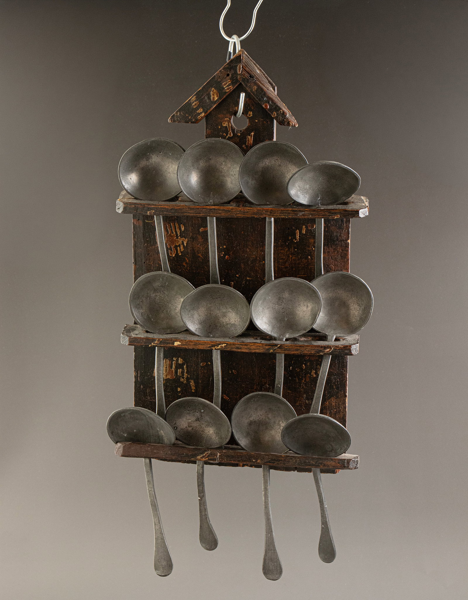 Pewter Spoons, Alsace: Set of 12 pewter spoons, Alsace, circa 17th–18th centuries. Length: 17 cm. Set in a wooden wall display rack. Rack dimensions: 38.5 × 19 cm. Flaws to the rack.