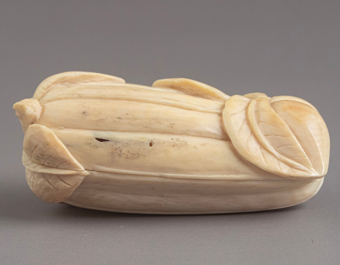 Carved Japanese Figurine: Japanese figurine, carved in the form of an opening gourd containing a couple in an erotic pose. Length: 5 cm. Signed.