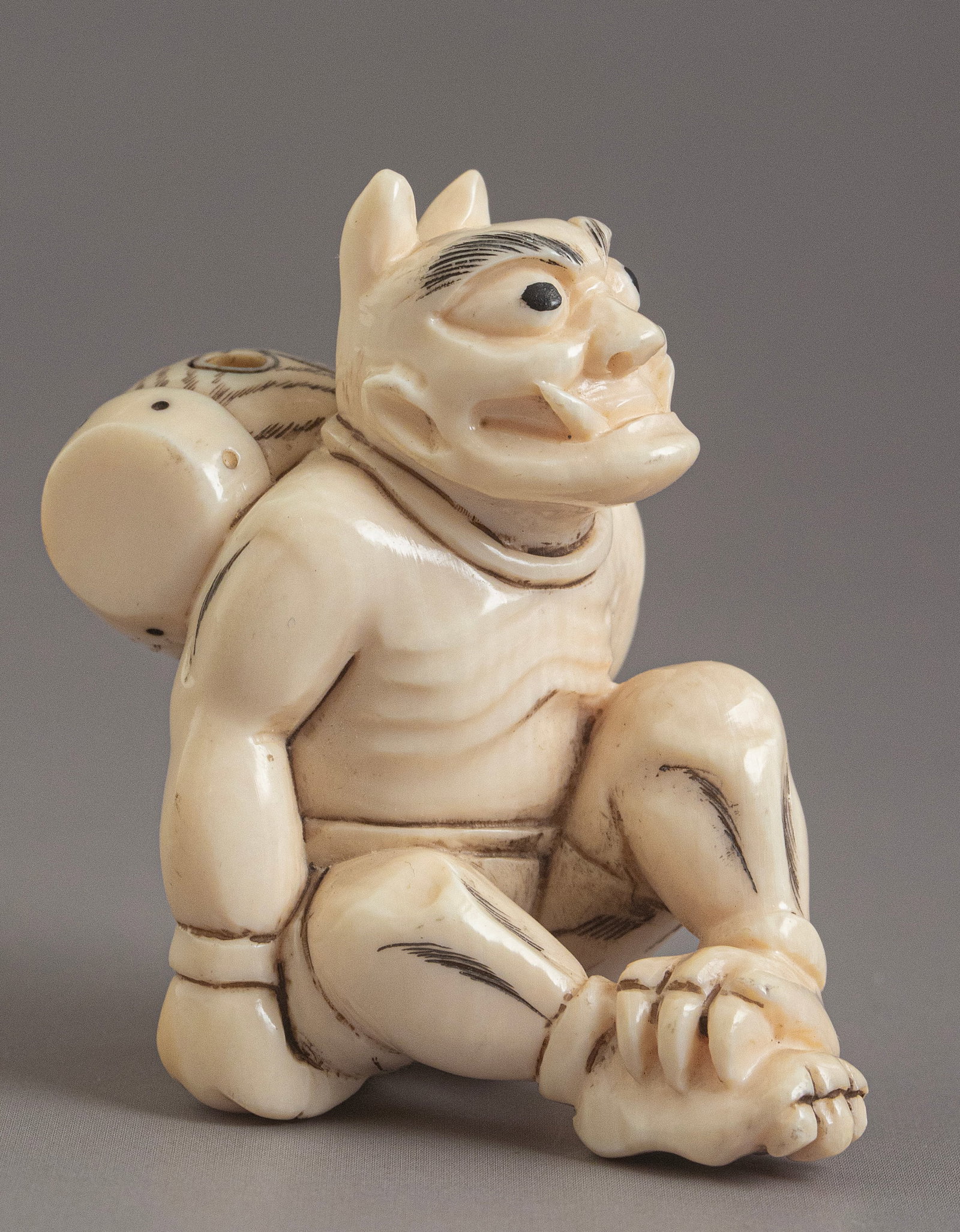 Carved Japanese Netsuke: Japanese netsuke, carved in the form of an oni (demon). Length: 5 cm. Signed.