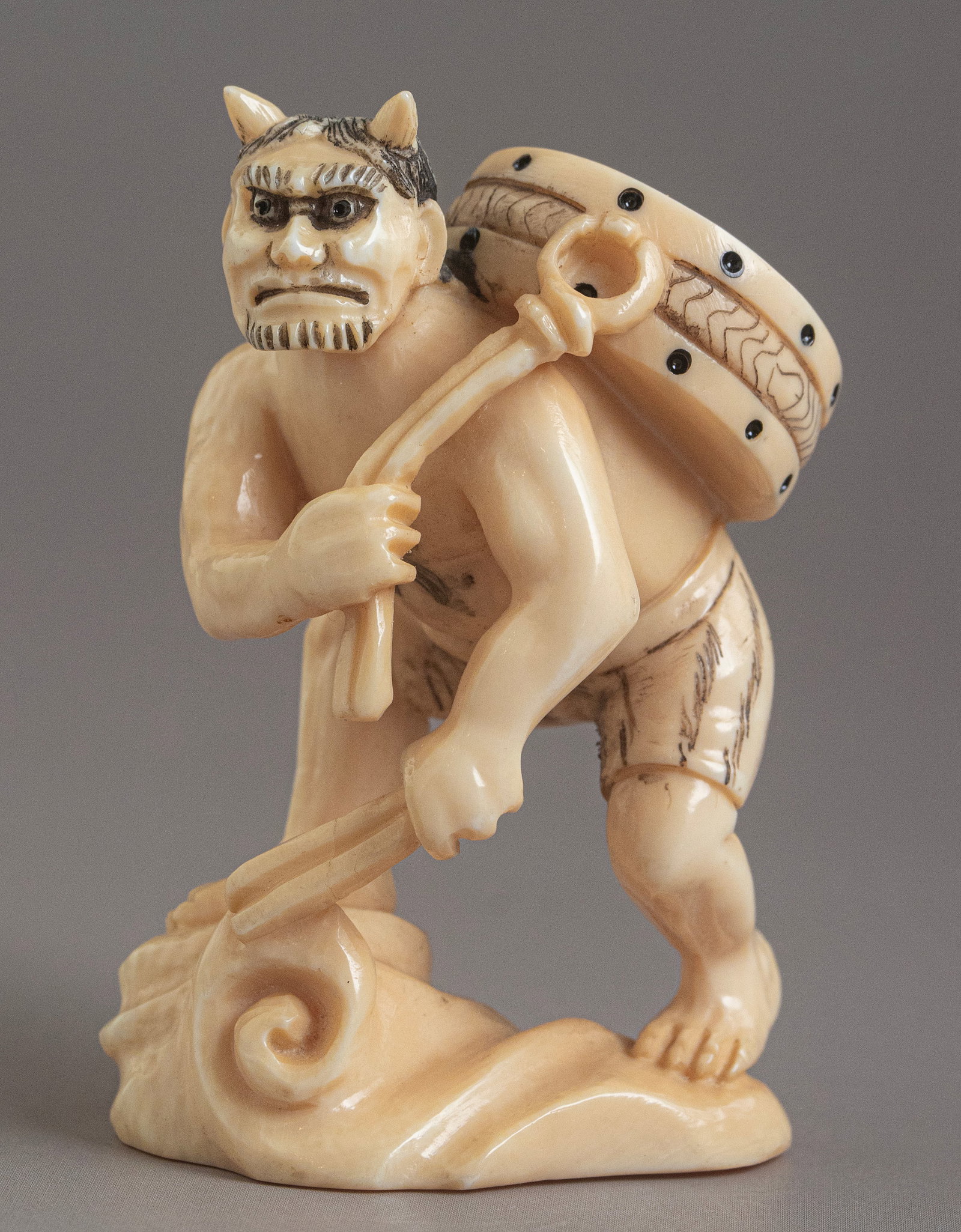 Carved Japanese Netsuke: Japanese netsuke, carved in the form of a demon holding a drum. Height: 5.5 cm. Signed.