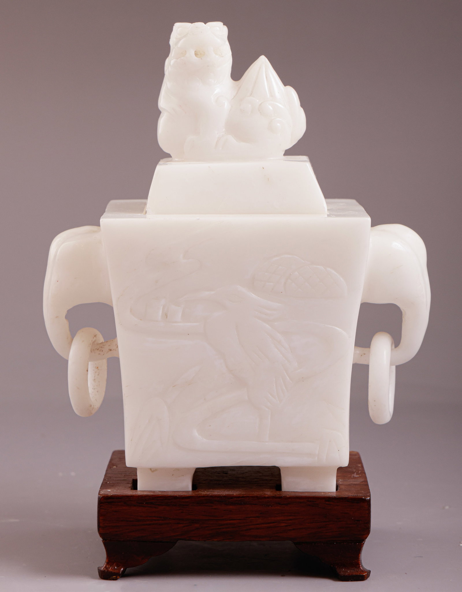 Chinese Incense Burner: Chinese carved incense burner, decorated with elephant heads and a Foo dog. Stands on a wooden base. Height (without base): 13.5 cm. Minor flaws.