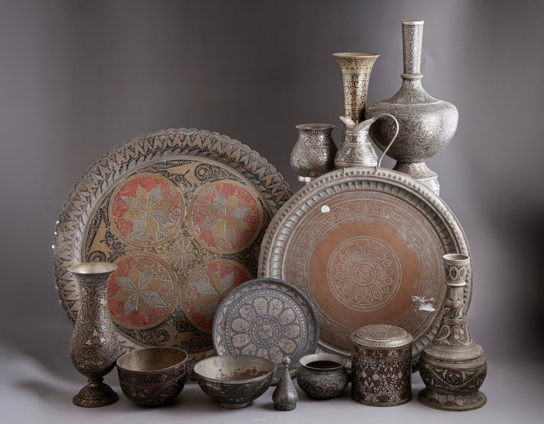 Indian Metalware: Large lot of Indian metalware, including trays, vases, bowls and a jug. Decorated with floral motifs. Height/length: 5–39.5 cm. Various conditions, flaws to some.