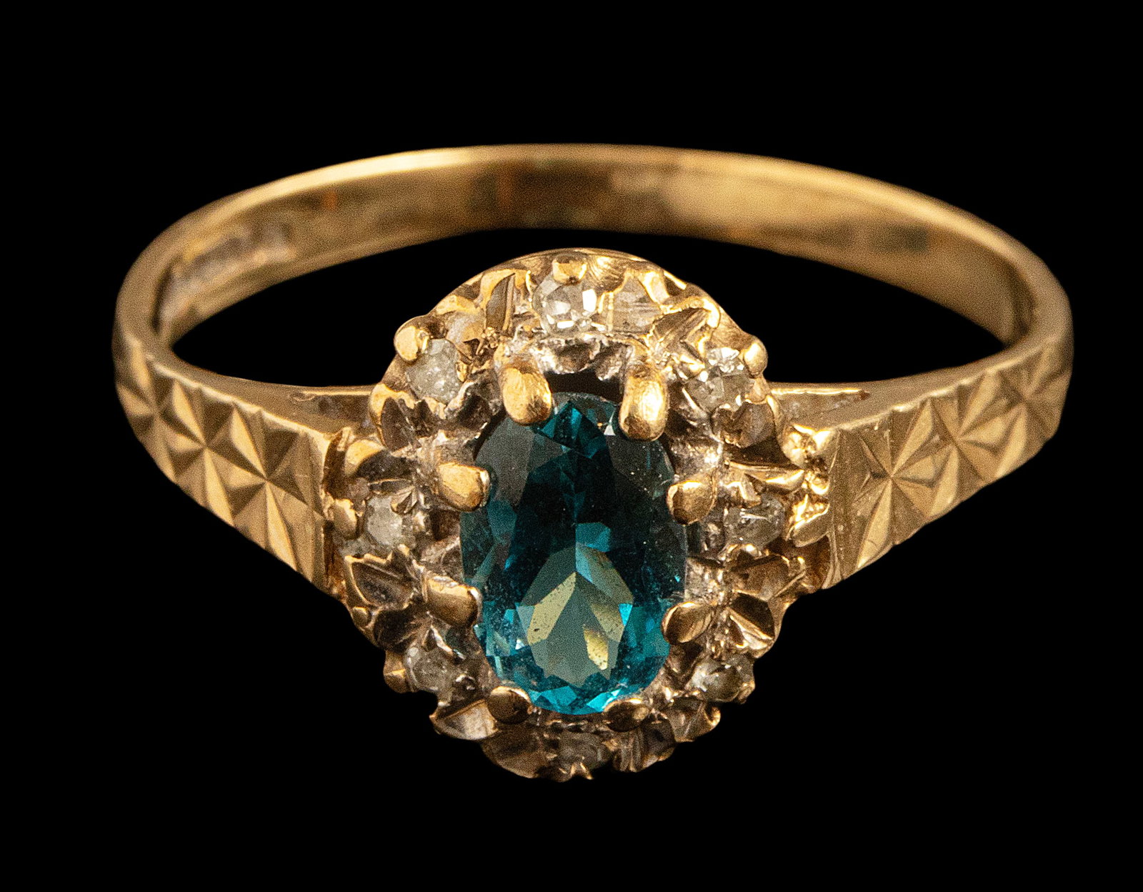 Gold Blue Topaz Diamond Ring: English 9K gold ring set with a central blue topaz (6 x 4 mm) and 8 diamonds weighing about 1 point each. Hallmarked.