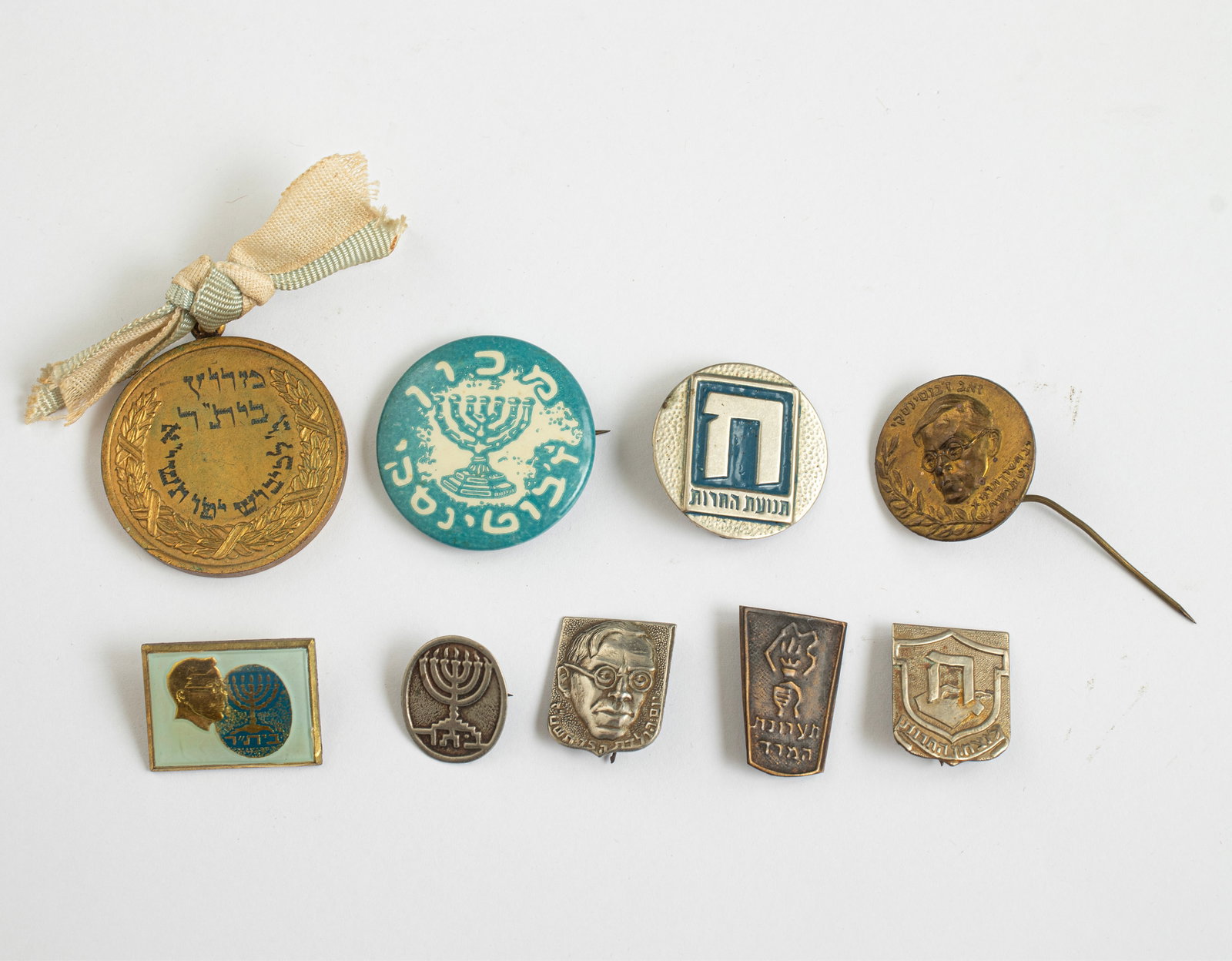 Badges and Medal, Related to Betar, Ze'ev Jabotinsky, and the Herut Movement: Lot of 8 badges, pins, and a medal related to Betar, Ze'ev Jabotinsky, and the Herut movement. Including a medal from the “Betar Race for the Conquest of Jaffa, 5711 (1951)".