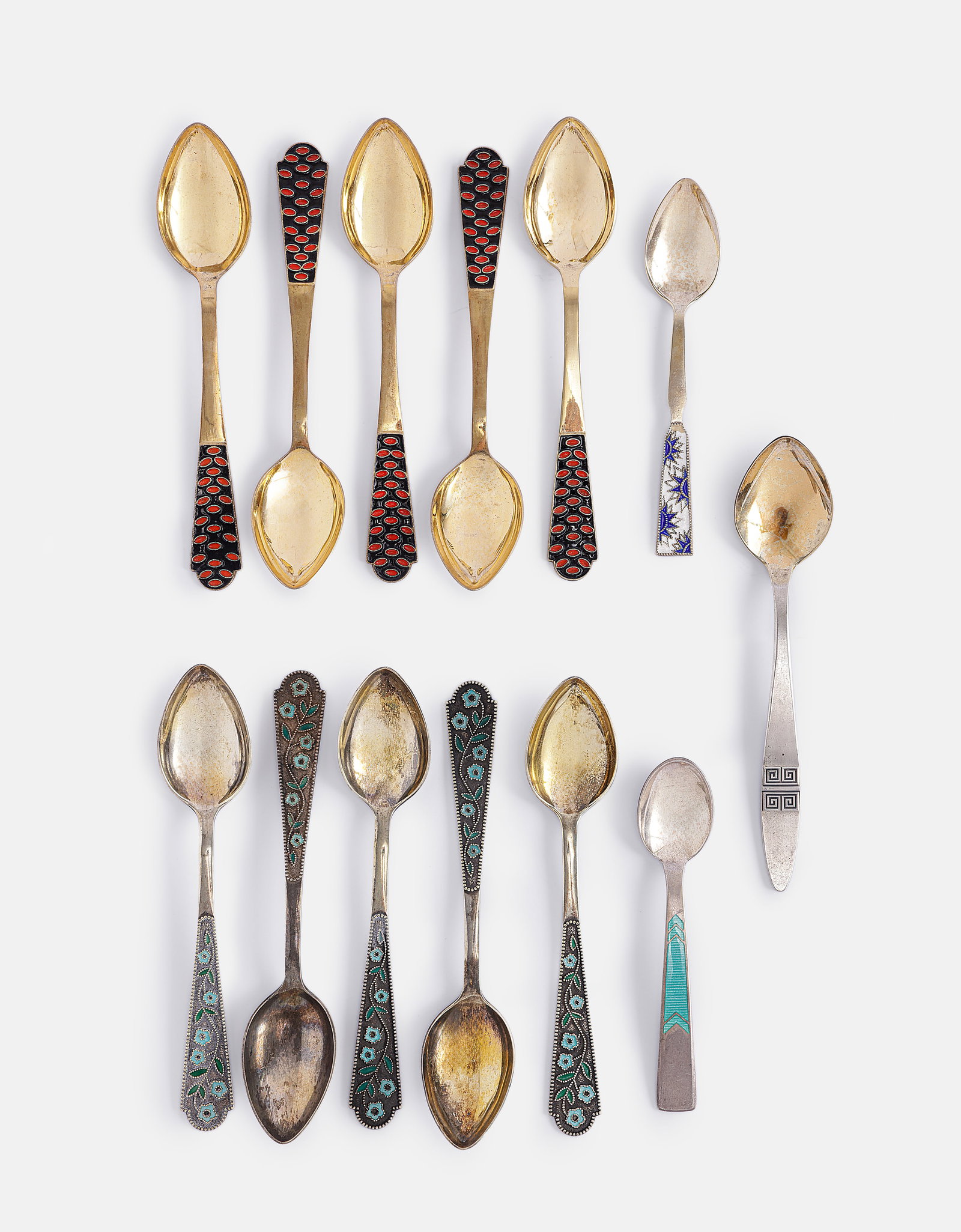 Russian Silver Teaspoons: Lot of 13 Russian silver (875–916) teaspoons. Most decorated with gilding and enamel work featuring floral motifs. Length: 11–14 cm. Total weight: 291 grams. Hallmarked.