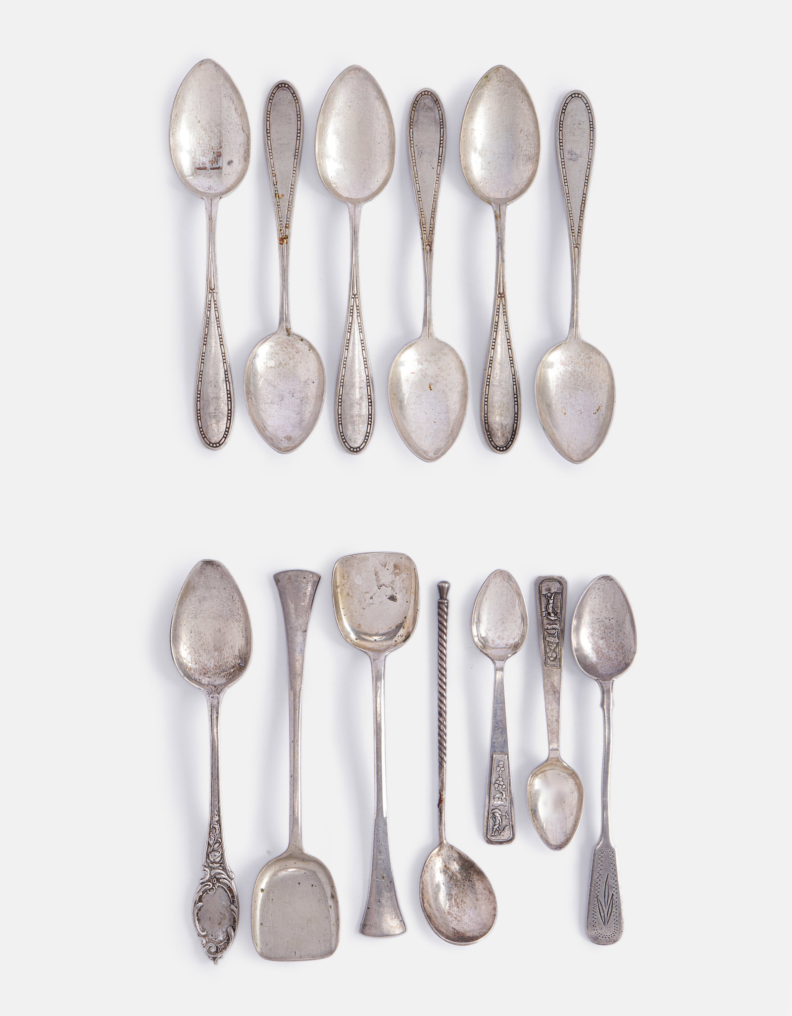 Silver Teaspoons, Various Origins: Lot of 13 silver teaspoons, various origins including Germany, Vietnam and others. Some decorated with figures and floral. Length: 10–14 cm. Total weight: 271 grams. Hallmarked.