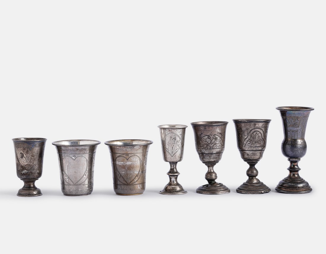 Silver Cups, Russia: Lot of 7 Russian 84 silver cups. Decorated with engraved floral motifs. Height: 6–10 cm. Total weight: 306 grams. Hallmarked. Minor dents to some of the bases.