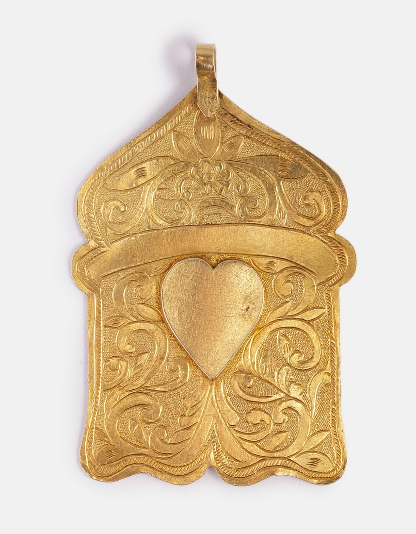 Gold Amulet: 18K gold amulet, North Africa. Engraved with floral motifs and a heart at the center. Dimensions: 7X4.5 cm. Weight: 17.2 grams. Unsigned, gold tested.