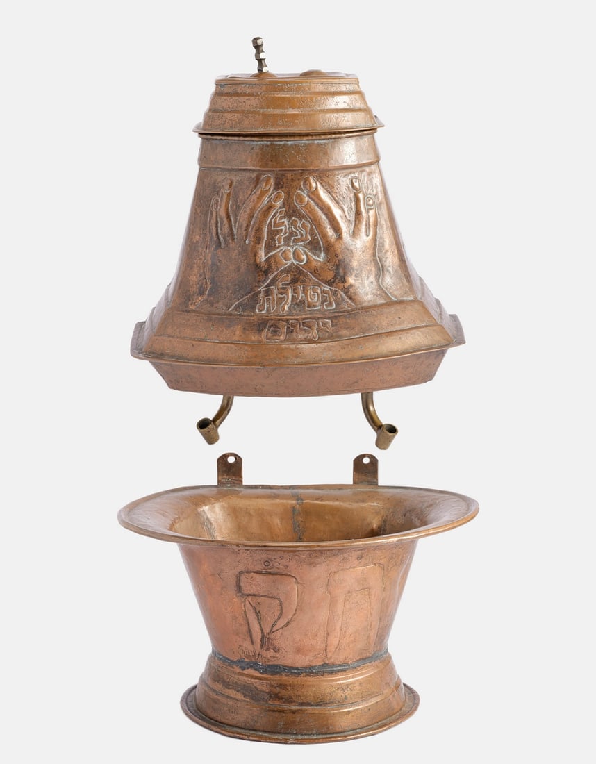 Copper Hand Washing Vessel, Chevra Kadisha: Copper hand washing vessel, Chevra Kadisha, circa 1900. Decorated with the Priestly Hands and a Hebrew inscription. Includes a bowl bearing the Hebrew initials. Height: 38 cm. Lacking the