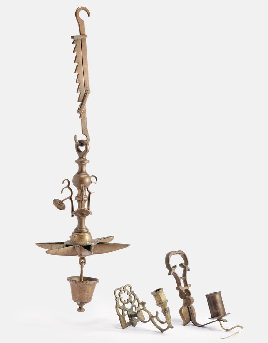 Bronze Lamps: Lot of 3 bronze lamps, including: * 19th century Jewish Shabbat lamp (Judenstern). Includes a bowl with six oil cups. Height: 71 cm. * Two wall lamps, decorated with openwork. Length: 14–20 cm.