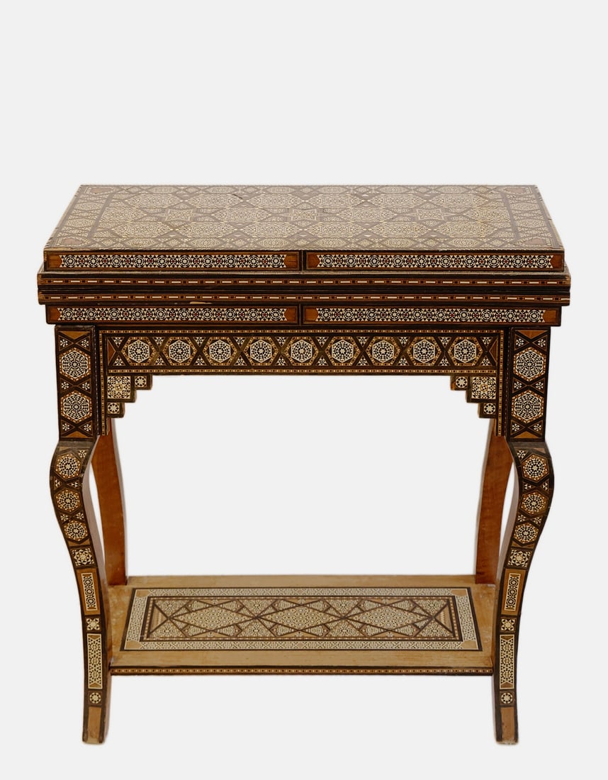Damascene Wooden Games Table: Fine wooden games table, inlaid with mother of pearl marquetry in Damascene style. Decorated with geometric motifs and carvings. The top swivels and opens to reveal a backgammon board (71X71 cm),
