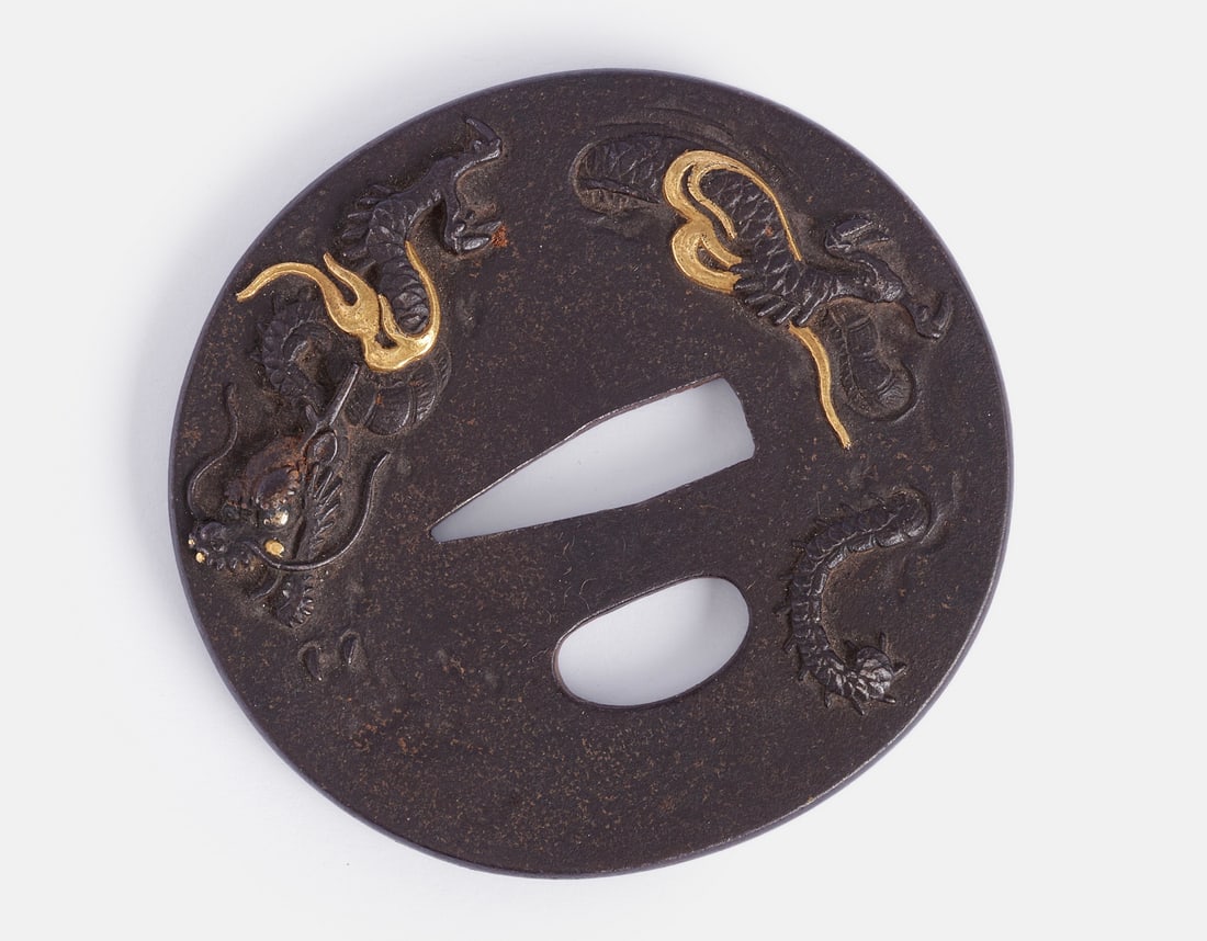 Japanese Bronze & Gold Tsuba: Japanese bronze and gold Tsuba. Decorated with dragons. Dimensions: 7X7.5 cm.