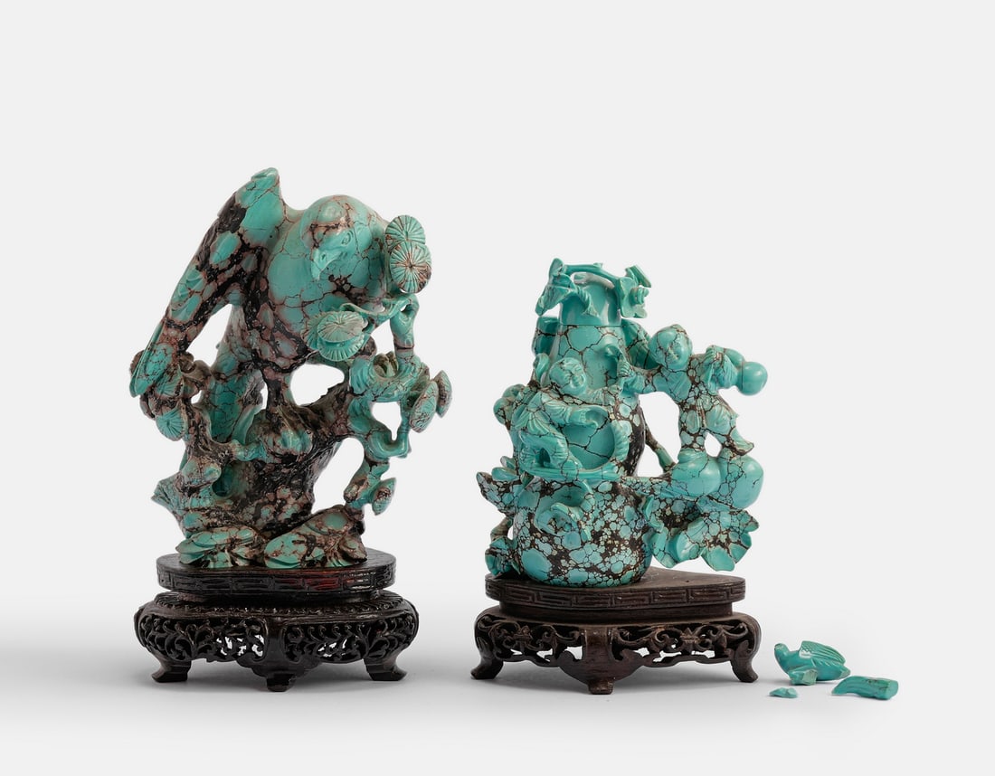 Chinese Turquoise Figurines: Lot of 2 Chinese turquoise stone figurines. Carved in the form of a bird on a tree and figures beside a gourd vine. Attached to wooden bases. Height: 8–13 cm. Flaws and breaks to one figurine.