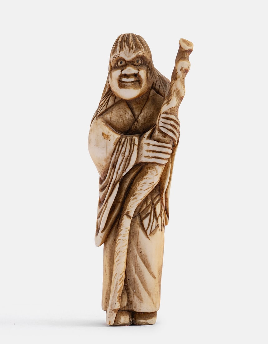 Carved Japanese Netsuke: Japanese netsuke, carved in the form of a man with a staff. Height: 7.5 cm.