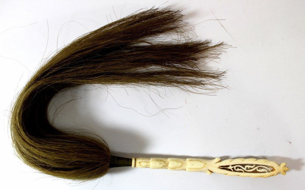 Antique African fly swatter: An Antique African fly swatter, with an ivory handle and horse hair. Length: 60 cm.