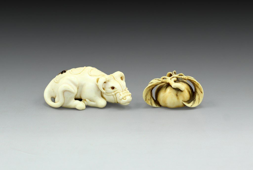 Japanese Ivory Figurines: Lot of 2 Japanese Ivory figurines shaped as an ox and a pumpkin. Length: 4-6 cm.