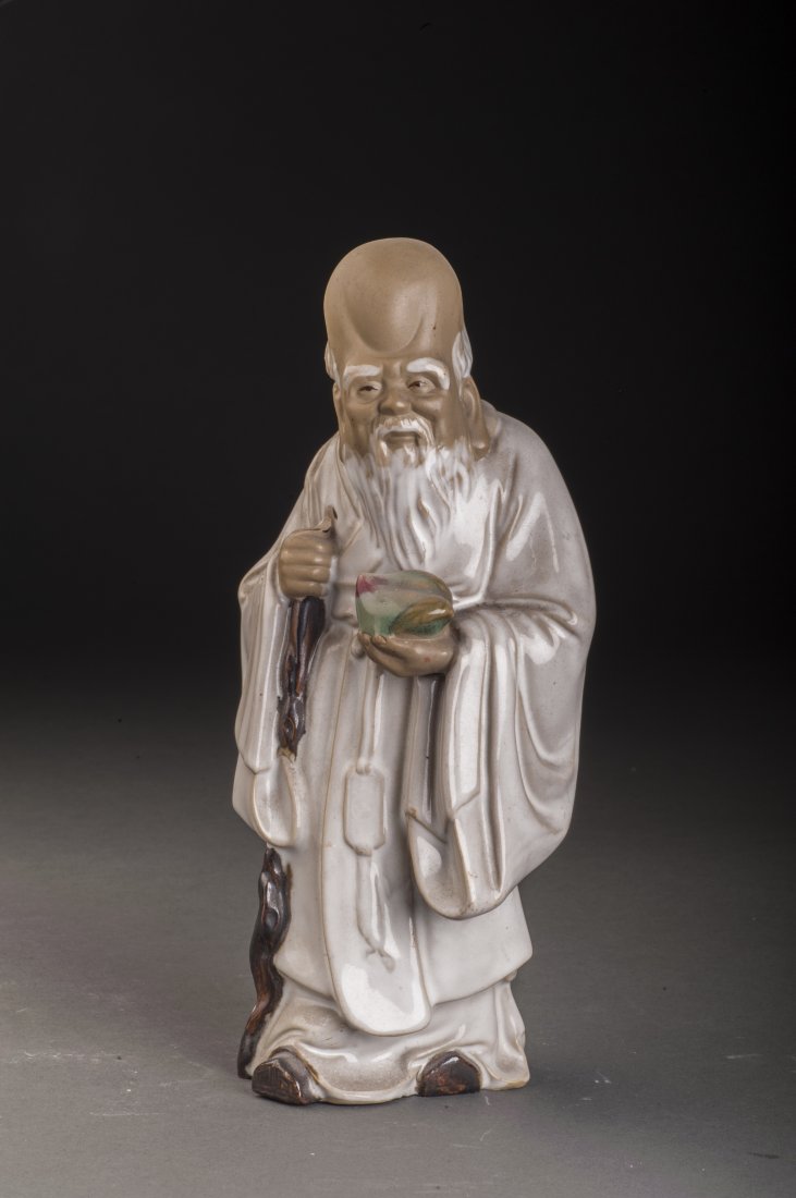 The God of Longevity: A vivid statue of the god of longevity. With a big and high forehead, the statue in long lobe, holding a vivid peach in his left hand. Face vividly expressed and carved in extremely detailed.