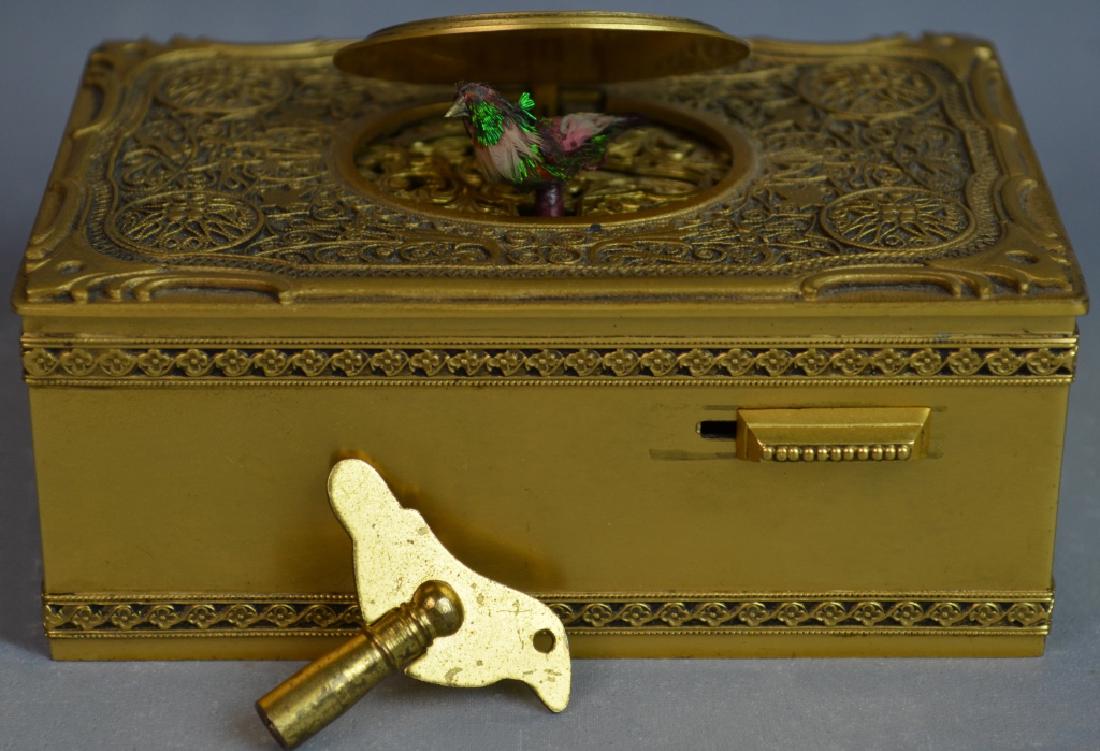 Bronze Bird Box: A bronze box with a wind-up. The dimensions of the box is 1 3/4 inches x 2 3/4 inches x 4 inches.