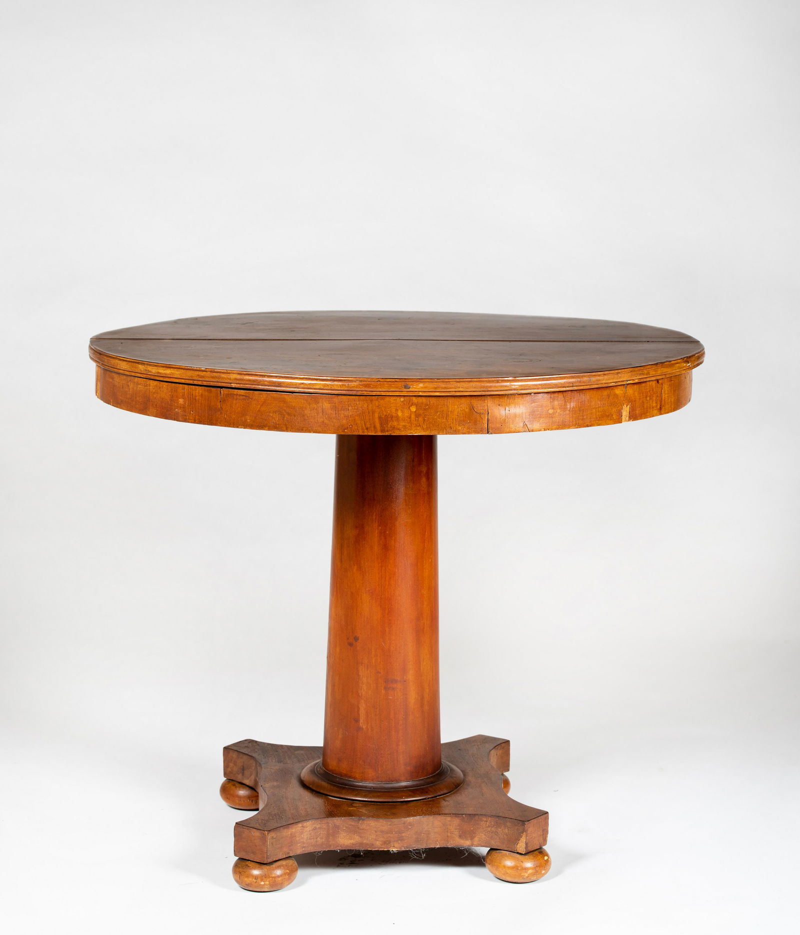 Round Mahogany Empire Center Table: Round Mahogany Empire Center Table, Having a 33" diameter book matched solid mahogany top with molded edge over a tapered cylinder shaft supported by a shaped platform base with four ball feet, old re