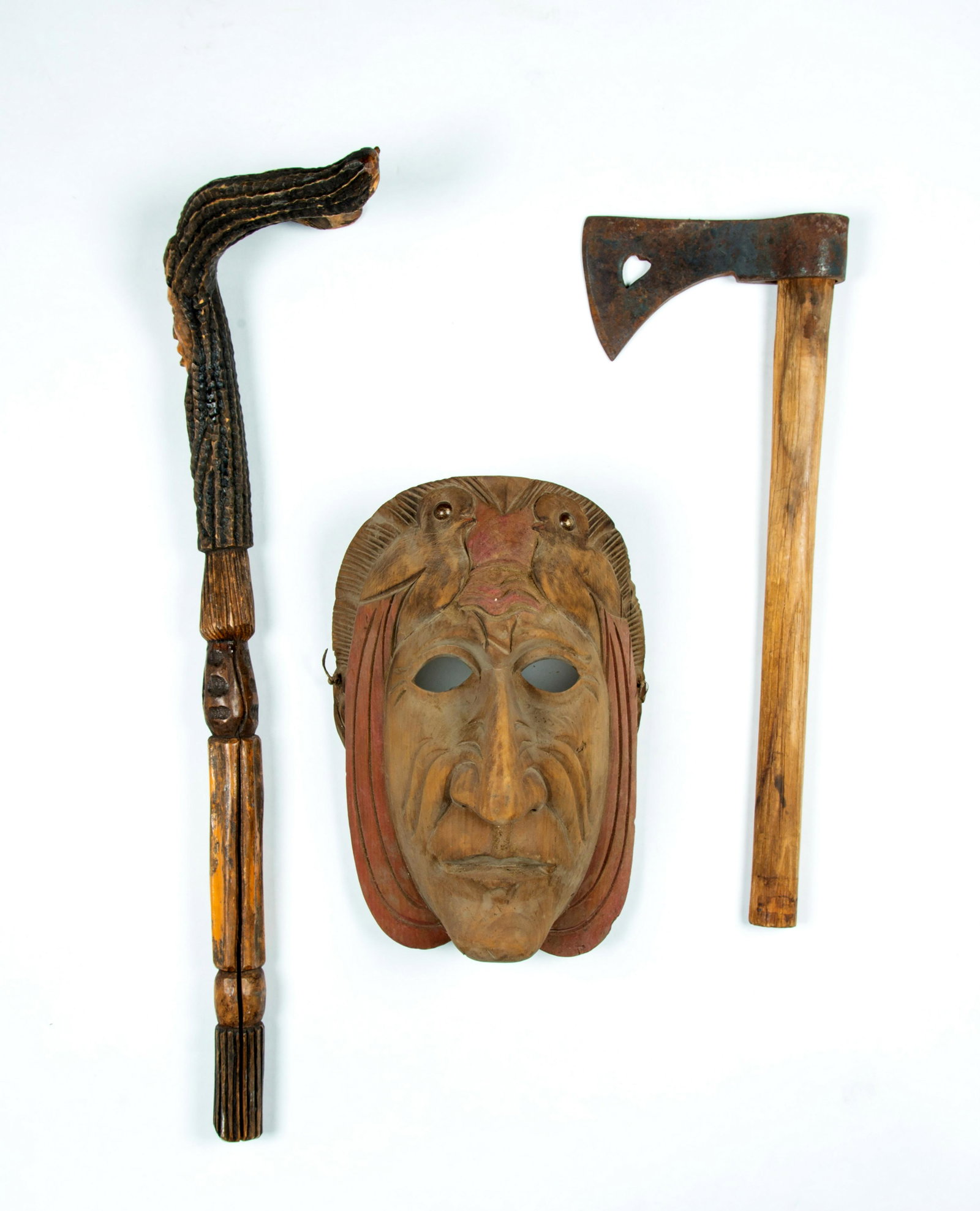 Lot of Three Native American Items: Lot of Three Native American Items, A) A tourist carved tree branch club, with a "Y" at the top, face and geometric carved shaft, 23" long. B) Vintage wrought iron hatchet head with heart cut out and 