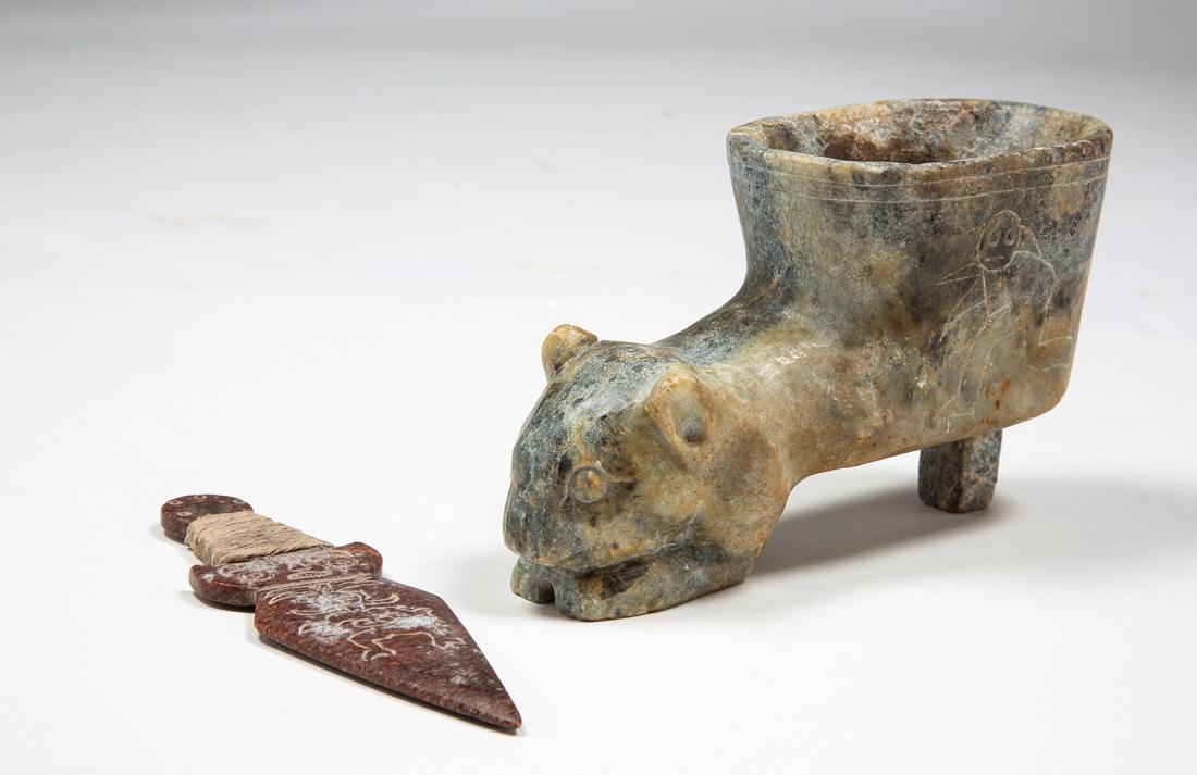 Two Pre-Columbian Jadeite Implements: Two Pre-Columbian Jadeite Implements, A) A 6 7/8" long decorated red jade ceremonial dagger, have a loop end, twine wrapped handle to hilt and diamond shaped blade, chassed designs on both sides of an