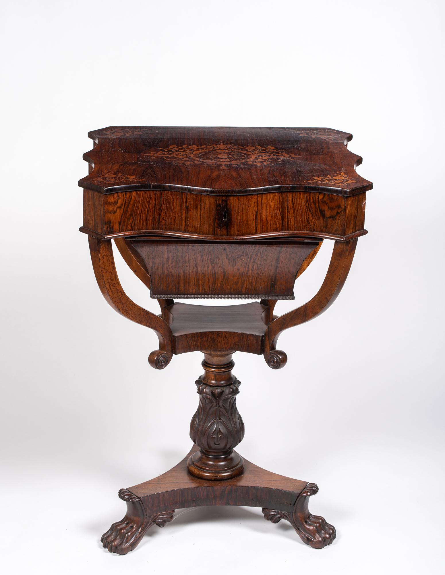English Regency Inlaid Rosewood Sewing Stand: English Regency Inlaid Rosewood Sewing Stand, Having a serpentine rosewood veneered top with intricate central floral design with matching corner inlays. The top lifts up to reveal a conforming case w