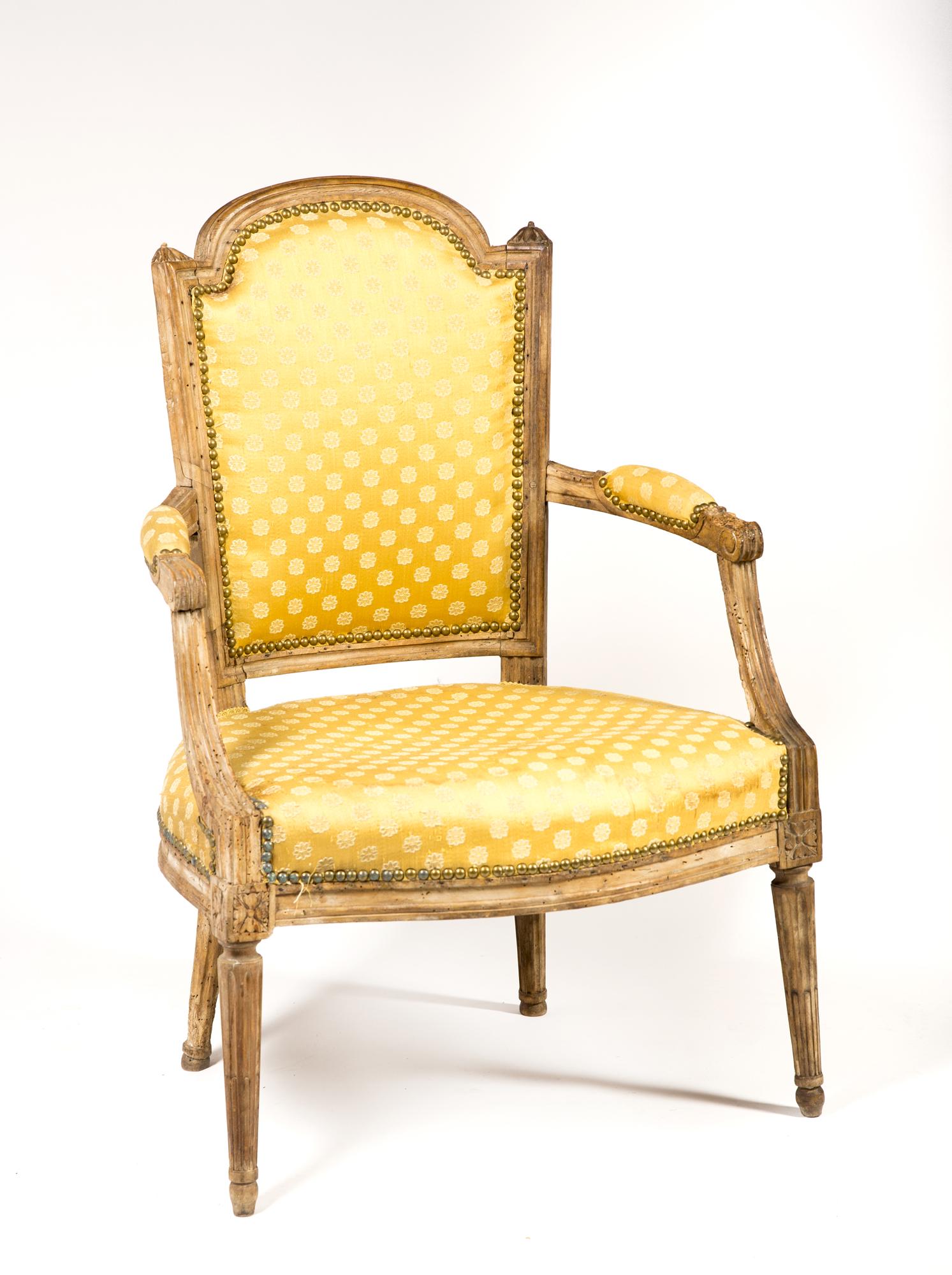French Louis XVI Armchair: French Louis XVI Armchair, Having an old refinished surface- some wormholes, yellow upholstery with stains, 23 1/2" wide x 22" deep x 35" tall, loss to left hand hold, 18thC/19thC. Estimate: $150 - $2