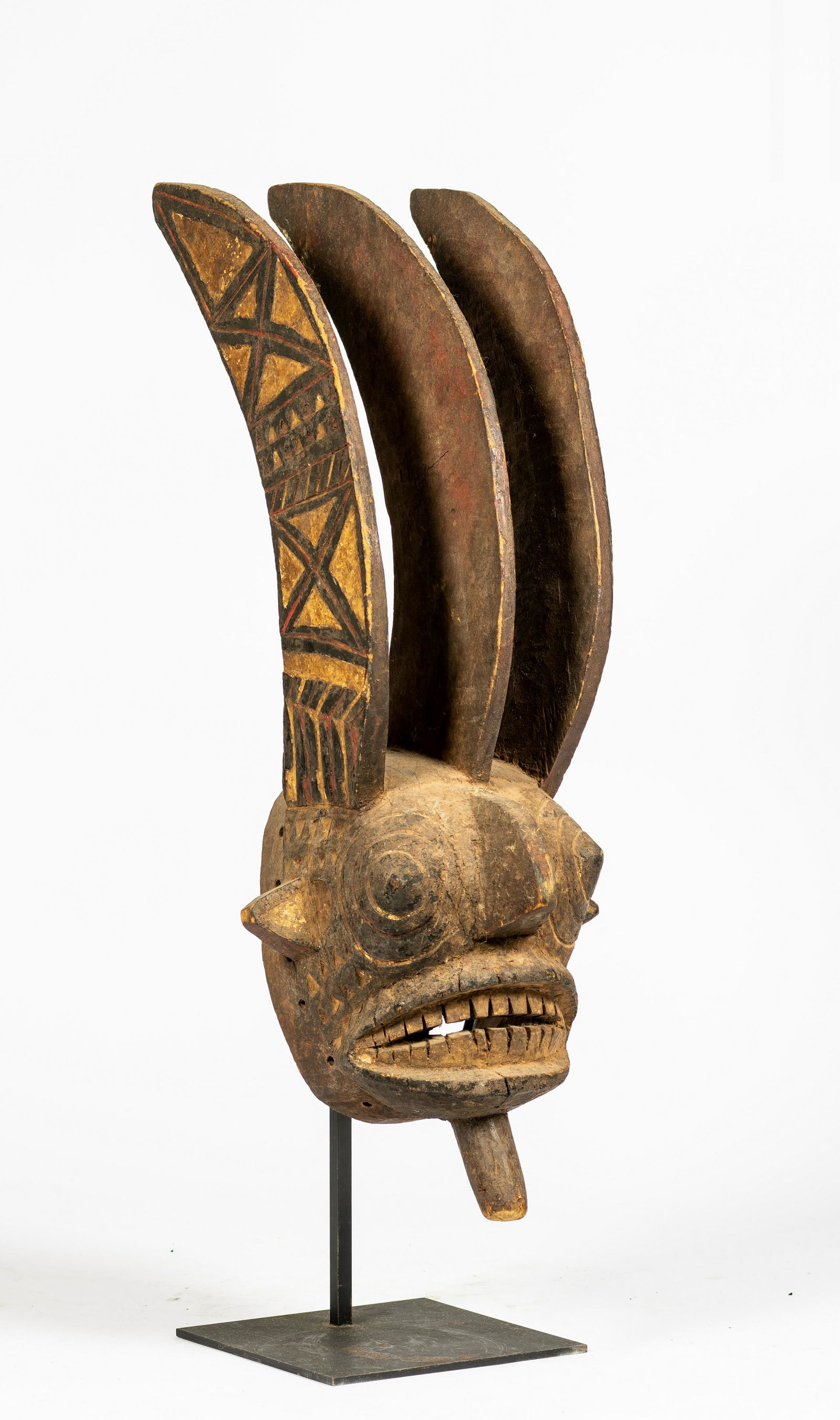 A Bobo/Mossi Mask, Burkina Faso: A Bobo/Mossi Mask, Burkina Faso, with concentric raised designs forming the eyes, raised central ridge nose, triangular protruding ears, wide open mouth with teeth, pommel to the chin' all below three