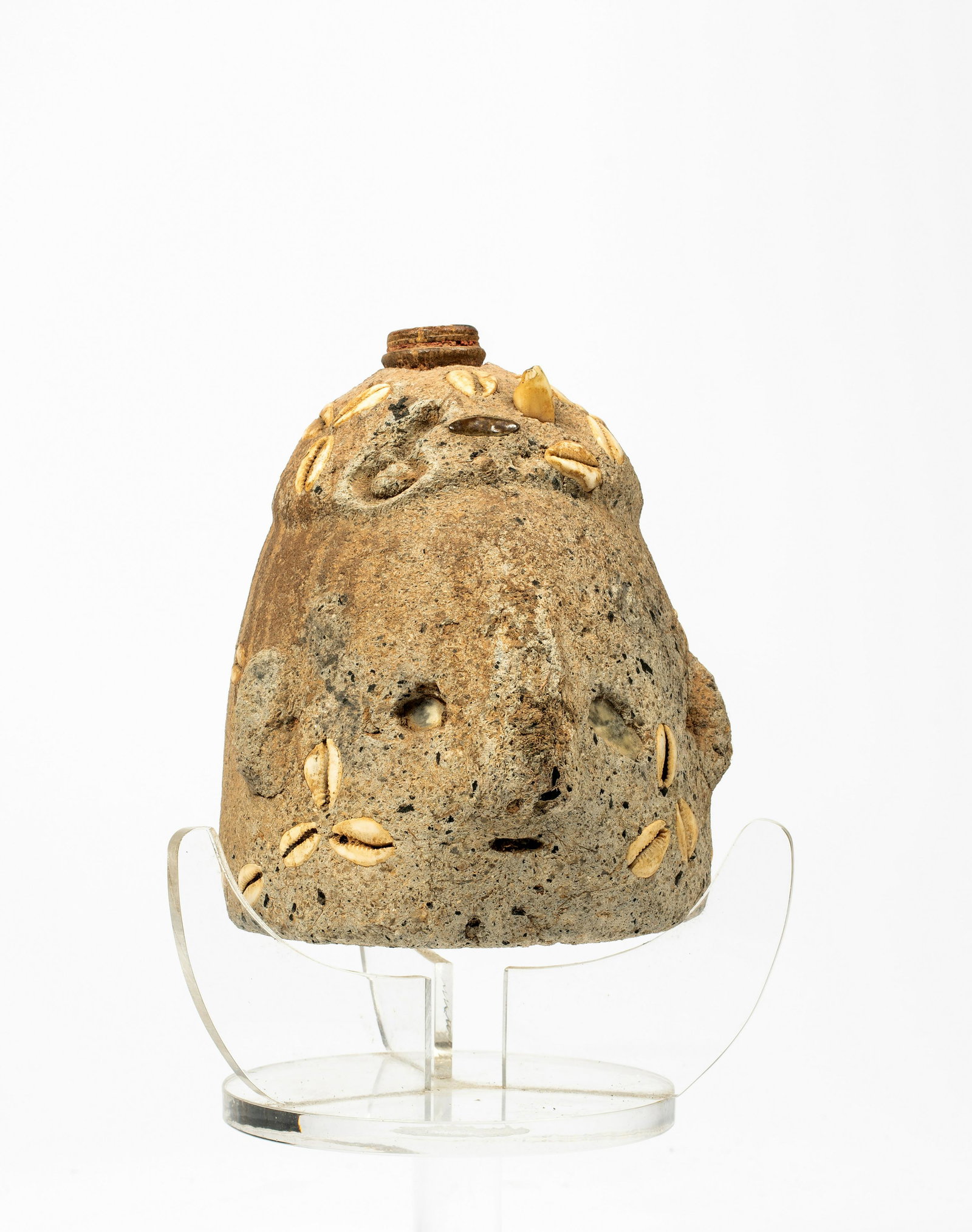 An Unusual Fetish Object: An Unusual Fetish Object, of cement in the form of a bust with inset mica for eyes, cowry shells and at least one tooth inset into surface, stopper to top, the object possibly made as a container, on 