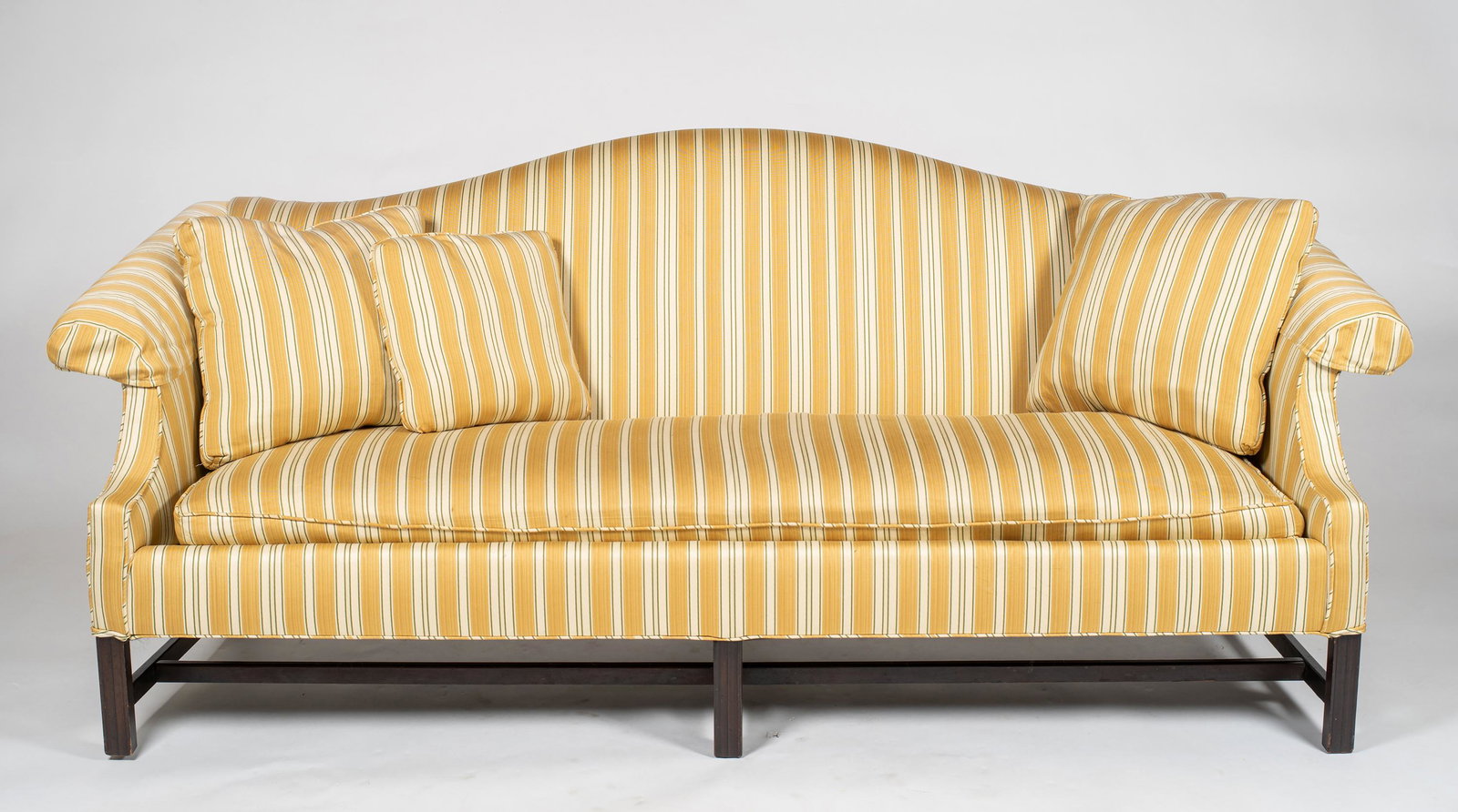 Chippendale Style Camelback Sofa, Having a clean striped gold and white upholstery, supported by: Chippendale Style Camelback Sofa, Having a clean striped gold and white upholstery, supported by molded straight legs, with two cushions, 35" tall x 76 1/2" long x 30" deep.