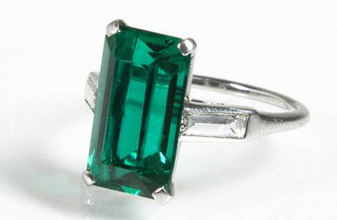 Cartier Emerald and Diamond Ring.: Cartier Emerald and Diamond Ring, a platinum 4 pronged setting holding a rectangular emerald flanked by two emerald cut diamonds approximately 10mm wide by 13mm long by 5mm deep. Emerald is approximat