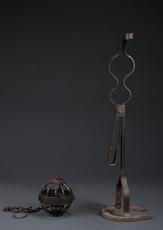 Wrought Iron Lighting Devices: Wrought Iron Lighting Devices; a gimbaled fluid lamp surrounded by ball form holder and chain for suspending and a 22" tall candle holder with horse shoe base, 18/19th century.