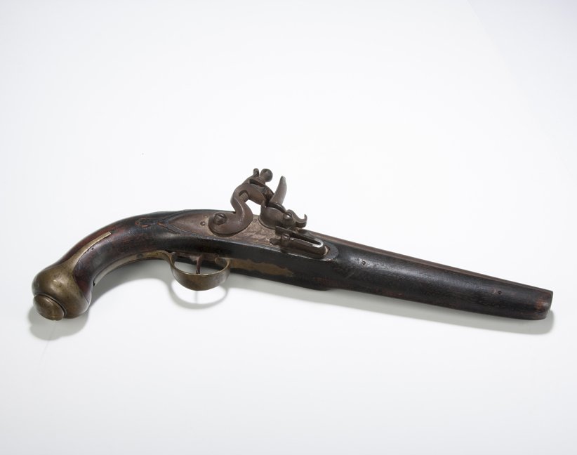 Early 19th Century Flint Lock Pistol, Probably of: Flint Lock Pistol, probably of Middle Eastern manufacture, walnut (?) grip with about 85% of its surface in a dark stain. Nicely carved details behind breach and mounted with simple brass trigger guar