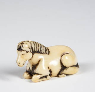 Ivory Netsuke of a Horse: Early Ivory Katabori Netsuke of a Horse lying down, unsigned with normal age cracking to ivory, 2" long. Provenance: The estate collection of Dr. and Mrs. Llewellyn Thomas Evans, Jaffrey, NH, purchase