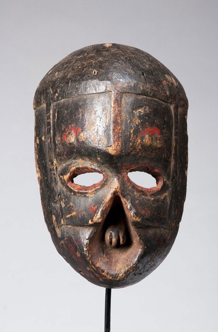 A fine and old Ibibio deformity mask: Ibibio, Nigeria; H: 7 3/4"The small mask with high raised forehead above tiny eyes, carved with no nose or upper lip and with teeth showing in the open face, possibly depicting syphilitic Yaws or a se