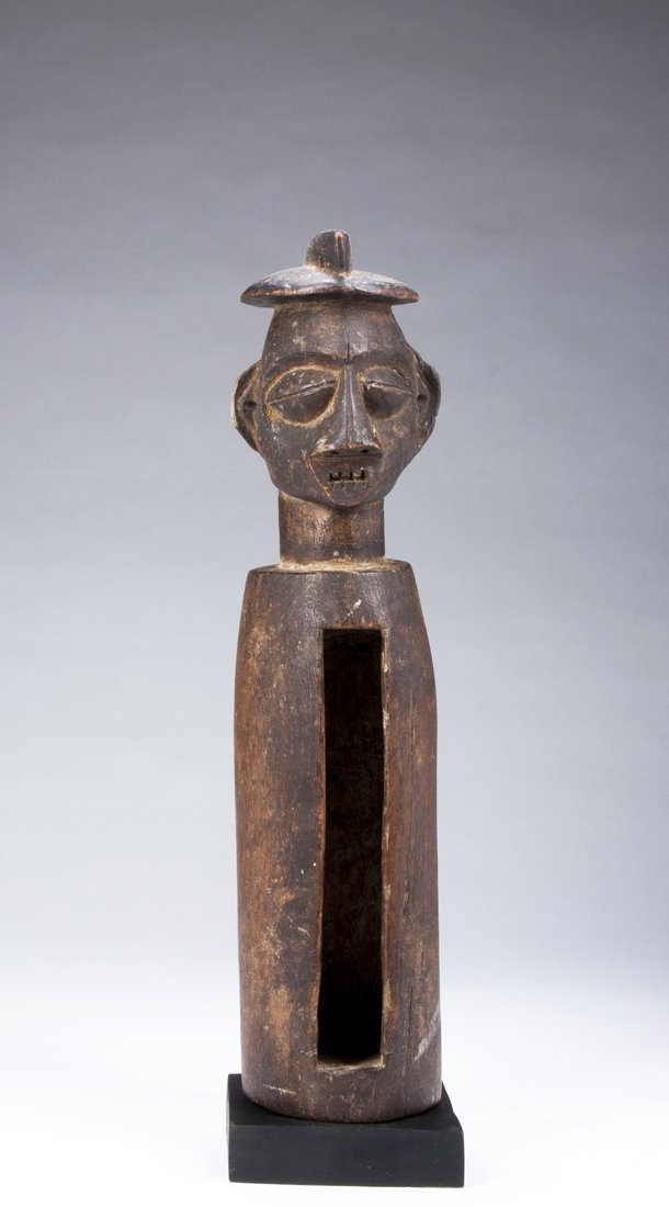 A Yaka diviners slit drum: Yaka, D.R. Congo; H: 15 3/4 inchesOf typical form, the large head with unusual coif over forehead with arching brows and raised swollen eyes. The nose wide and aggressive with barred open mouth, the l