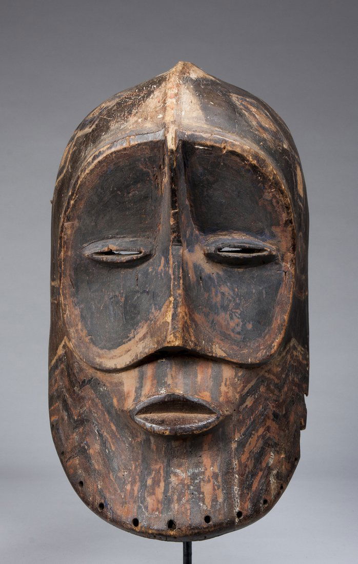 A rare Bena Lulua helmet mask: Bena Lulua, D.R. Congo; H: 13"The mask with large ocular plane bisected by the nasal ridge, the mouth small and with pursed lips beneath the small nose. The mask with linear painted patterns and desig