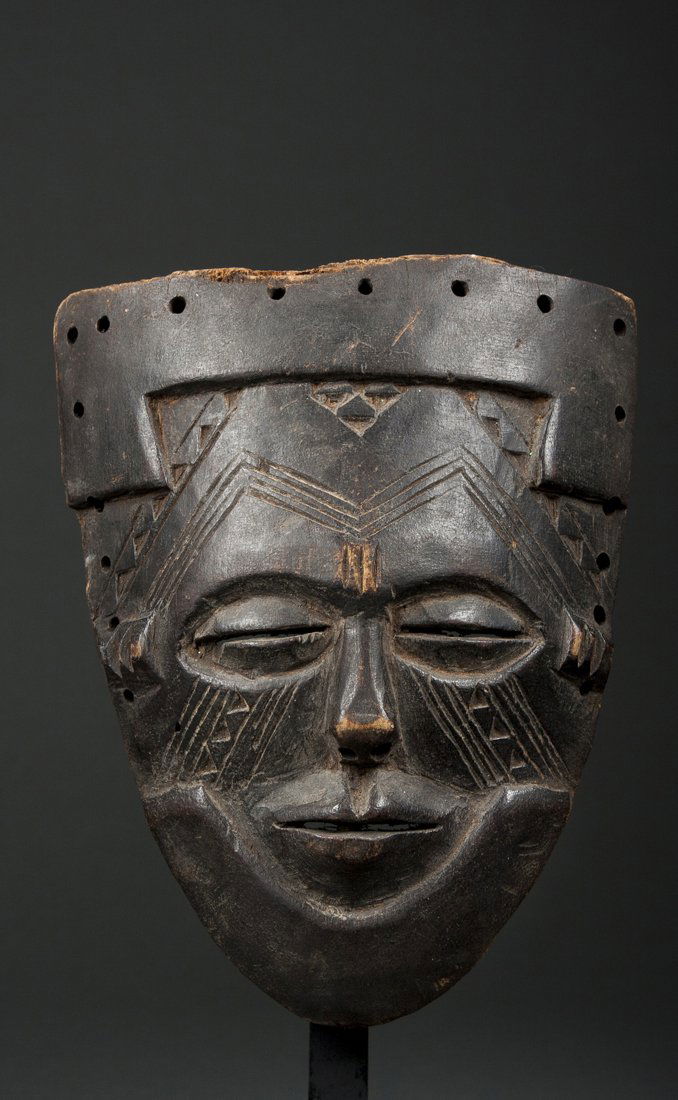 A small Kuba mask: Kuba Shoowa or Lele, D. R. Congo; H: 7"The small mask with elaborate raised Kuba design elements all over the surface, the face of classical form with small swollen eyes, tiny nose and pursed lips. Ma