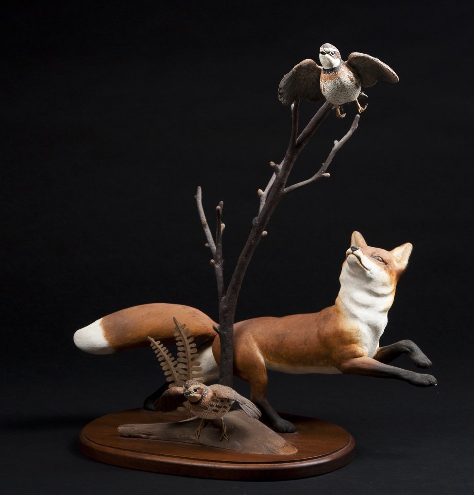 Robert & Virginia Warfield, signed wood carving of a: Robert & Virginia Warfield, wood carving of a red fox in leaping position looking at a Bobwhite quail on a branch with another quail getting ready to fly, signed and identified on bottom, and "198