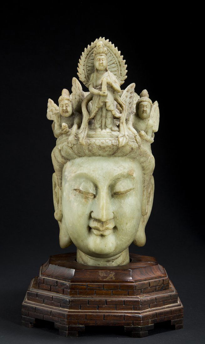 Carved Chinese Hard Stone Bust: Carved Chinese Hard Stone Bust, of a woman wearing a head dress of winged figures, 13 1/2" tall, set on a stepped wooden base, some damage to crown.Estimate: $1,000 - $1,500