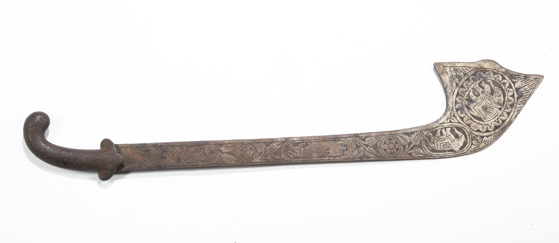 An Indo-Persian Kora: The unusually shaped iron Parade Weapon of classical form completely covered with floral motifs, the blade with floral designs and cartouches depicting elephants and felines, 27" long. Some oxidation,
