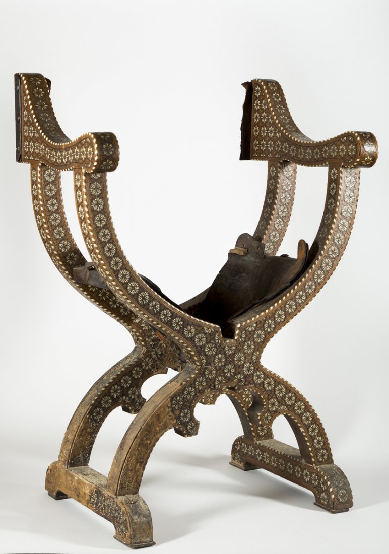 Middle Eastern Inlaid Chairis: Middle Eastern Inlaid Chair, central hinged joint allows the chair to be partially folded up, tooled leather seat and back are partially missing, chair has a wooden frame which is totally covered in f