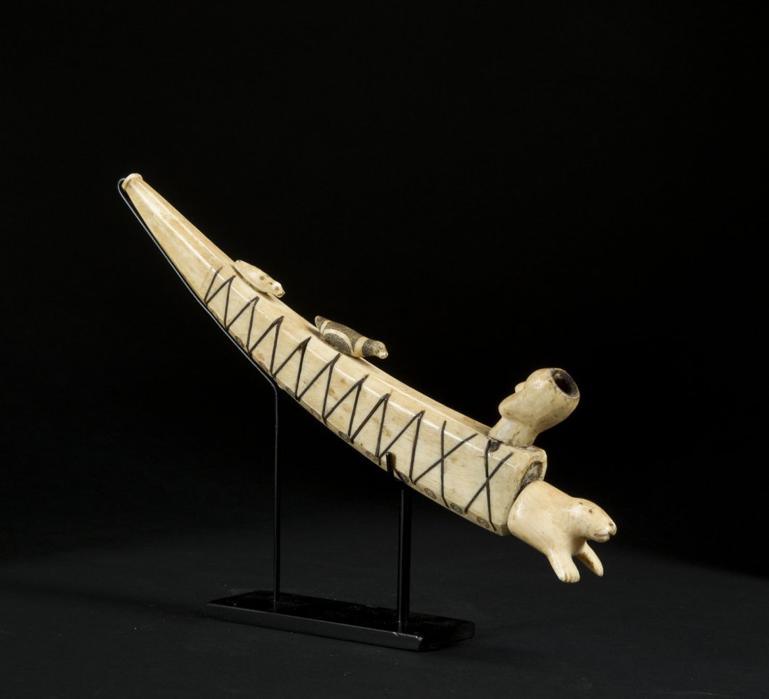 An exceptional Inuit baleen inlaid pipe with elaborate: An exceptional Inuit baleen inlaid pipe with elaborate carving. 19th. C The narrowing stem of the pipe taking the form of the walrus tooth with flanged bit, the body with zigzagging incised lines with