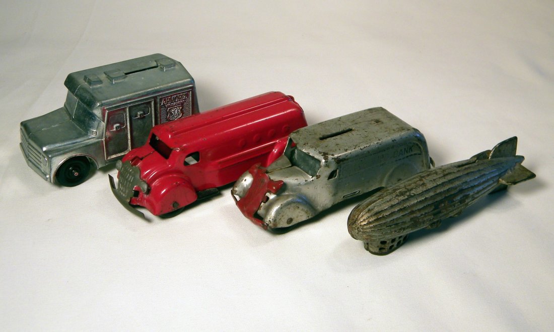 Lot of Four Still Banks: A.C. Williams cast iron Graf Zeppelin with considerable paint wear, WM Armored Truck Bank by Callen Mfg. Co, red heavy tin Armored Truck bank in excellent condition by Wyandotte Mfg. Co., and a Marx h