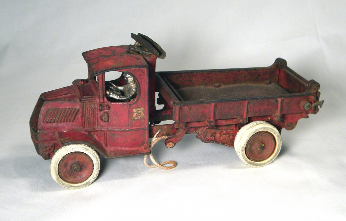 Arcade Cast Iron Mack Dump Truck: Arcade cast iron Mack Dump Truck with rubber tires, one lift pulley missing, 12" long.