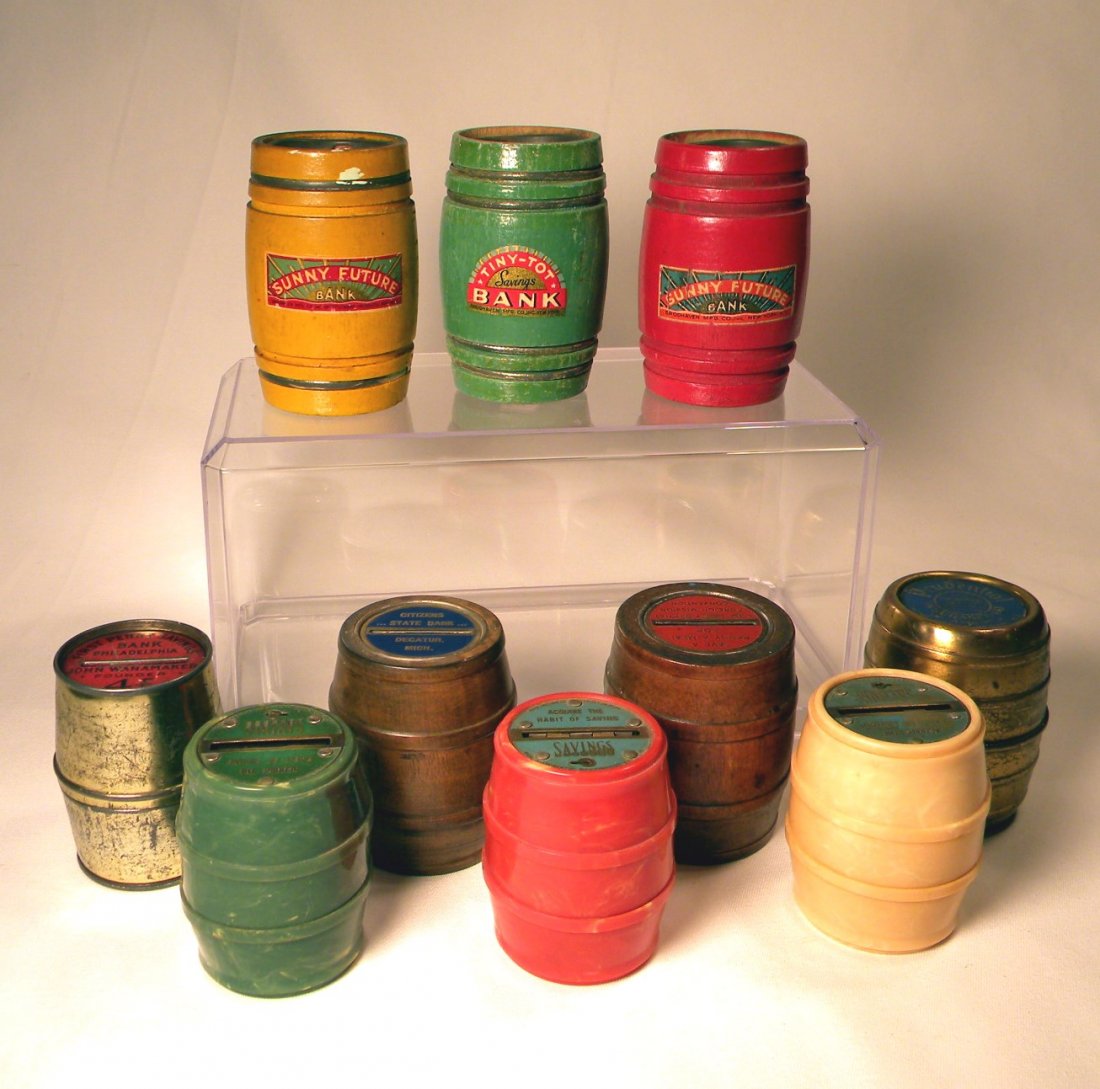 Lot of Ten Barrel Banks: Lot of 10 Barrel banks; 2 wood "Sunny Future Bank" yellow and red, wood "Tiny-Tot Savings Bank", 3 plastic "Maine Savings Bank, Portland, ME" in assorted colors, tin "First Penny Savings Bank, Philade