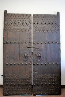 Pair of Early Chinese Wood and Iron Temple Doors: Pair of heavy wood temple doors. Hand wrought iron hardware. Foo dog head and ring pulls; 85in.H. x 29in.W.(each door) x 2in.(thickness)