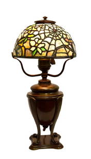 American Leaded Miniature Cobweb Lamp: A miniature leaded salesman's sample cobweb lamp in the manner of Tiffany. Original Tiffany Studios bronze urn base. Impressed at the underside, Tiffany Studios New York; 15.5in.H. x 7.25in.D.(shade)